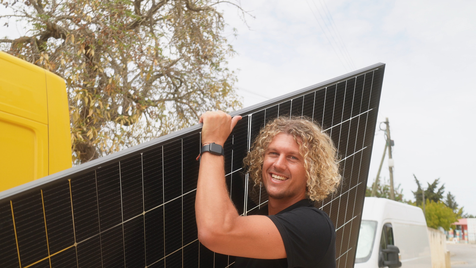 Fundador con panel solar frente a los vehículos Voltaicos en el Algarve